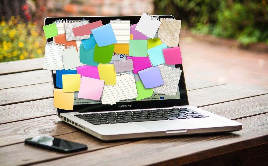 Laptop covered with sticky notes.